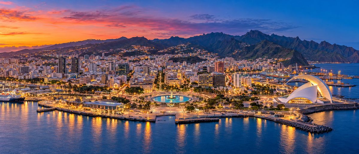 An international coastal city lit up at dusk